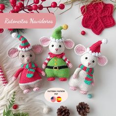 three crocheted mice in christmas outfits next to pine cones