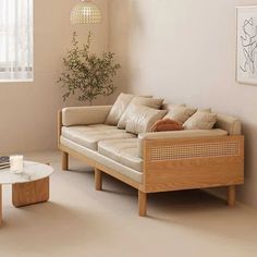 a living room filled with furniture next to a white coffee table and wall mounted plant