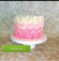 a pink and white cake sitting on top of a table