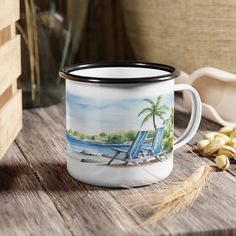 a coffee mug with a beach scene painted on the inside sits on a wooden table