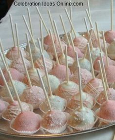 there are many pink and white candies on the plate with toothpicks in them