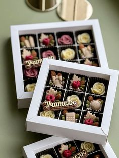 two boxes filled with assorted chocolates on top of a table