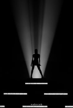 the silhouette of a woman standing in front of spotlights with her hands on her hips