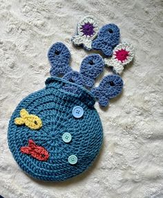 a crocheted blue purse with three little fish on it