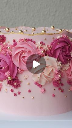 a pink and gold decorated cake with flowers on it