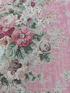 an old rug with flowers and leaves on the ground in front of a pink background