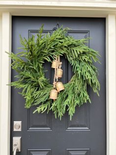 a wreath with bells hanging on the front door