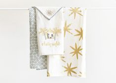 two towels hanging on a clothes line with the words congratulations written in gold and white