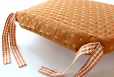 a close up of a cushion with a ribbon tied around it on a white surface