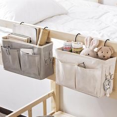 two storage bins with stuffed animals in them on the side of a bunk bed