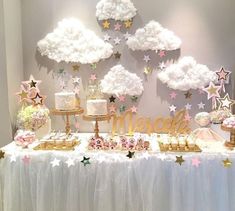 a table topped with cakes and desserts covered in white frosted stars next to a wall