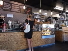 a woman standing in front of a counter at a restaurant