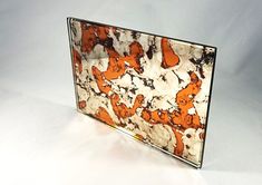 an orange and white marbled glass block with bears on it's sides is shown