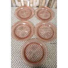 four pink glass plates sitting on top of a table