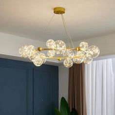 a chandelier hanging from the ceiling in a living room with blue walls and curtains