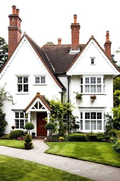 Charming white house with red chimneys amidst lush greenery. Explore the quirky charm, secret staircases, and unintentional labyrinths of British country houses, where historical oddities meet modern mishaps in the most delightful way.