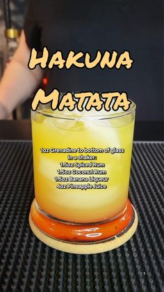 a close up of a drink on a table with the words hakuna matata above it