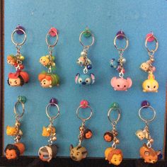 a bunch of key chains that are hanging on a blue wall in front of a black frame