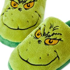 a pair of green slippers with the grin face drawn on them