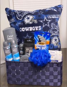 a blue gift basket with personal care products and toiletries in front of a pillow