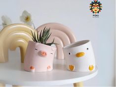 three ceramic pig planters sitting on top of a white table next to each other