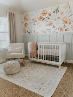 a baby's room with floral wallpaper and a white crib