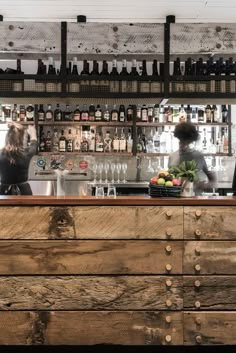 the bar is made out of wood and has bottles on it