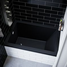 a black bath tub sitting in the corner of a bathroom