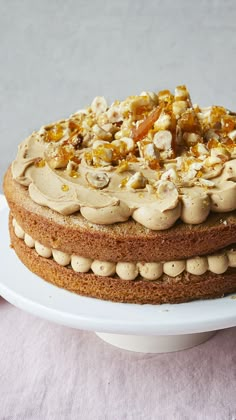 a cake with nuts and frosting on a white plate