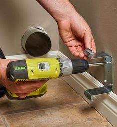 a man using a drill to fix a hole in the wall