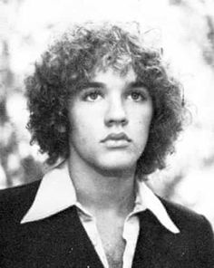 an old black and white photo of a man with curly hair