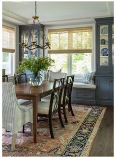 a dinning room table with chairs and a bench in front of the dining room window