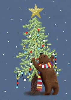 a brown bear standing next to a christmas tree