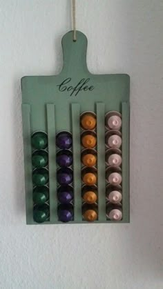 there are many different colored candles hanging on the wall with words coffee and tea in them