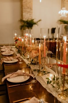 a long table with candles and plates on it