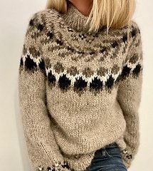 a blonde woman wearing a sweater and jeans