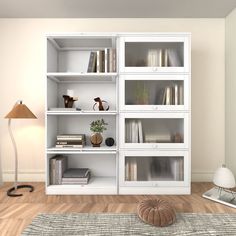 a white bookcase with many books on it and a lamp in the corner next to it