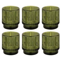 six green glass candlesticks sitting next to each other