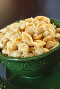 a green bowl filled with macaroni and cheese