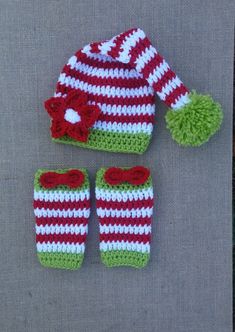 a crocheted hat, mittens and booties are sitting on a piece of cloth