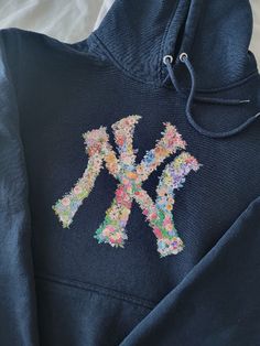 Vibrant and beautiful New York Flower Hoodie! New York Yankee Hoodie, Navy Aethstetic, Stitch Work Hoodie, Fabric Sweatshirt Design, Embroidery Hoodies Inspiration, New York Yankees Hoodie, New York Essentials, How Lucky Are We Hoodie, Cricket Hoodie Ideas