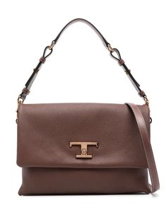 The Tod's T Timeless Tote Bag is crafted from calf leather with a pebbled texture. It features a foldover top with a T Timeless turn-lock buckle fastening, a single detachable adjustable top handle, an adjustable detachable shoulder strap, and an accordion design. The bag has a partitioned compartment, multiple internal slip pockets, and a suede lining. It also features a gold-tone logo plaque, gold-tone hardware, and an internal logo stamp. The bag comes complete with a protective dust bag. Red Valentino Shoes, Zegna Shoes, Timeless Wardrobe Staples, Golden Goose Shoes, Valentino Shoes, Logo Stamp, Red Shoes, Beautiful Shoes, Luxury Shoes