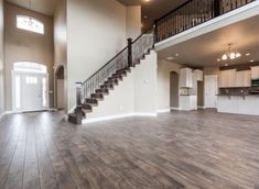 a large open floor plan with stairs leading up to the second story and kitchen area