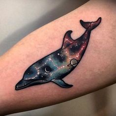 a tattoo on the arm of a woman with a whale in space and stars painted on it