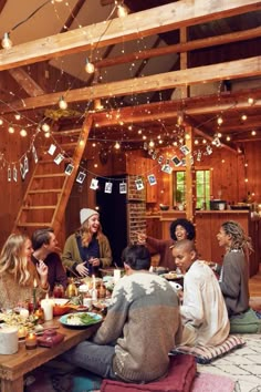 a group of people sitting around a table with food and drinks in front of them