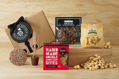 an assortment of snacks including popcorn, cookies and other items on a wooden table top