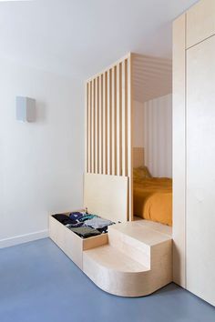 an unusual bed is built into the wall in this bedroom with blue flooring and white walls