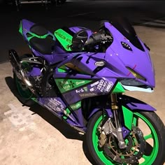 a purple and green motorcycle parked in a parking lot