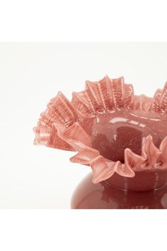 a pink vase sitting on top of a white table