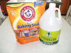 a bottle of baking soda next to a bag of vinegar on a kitchen counter top